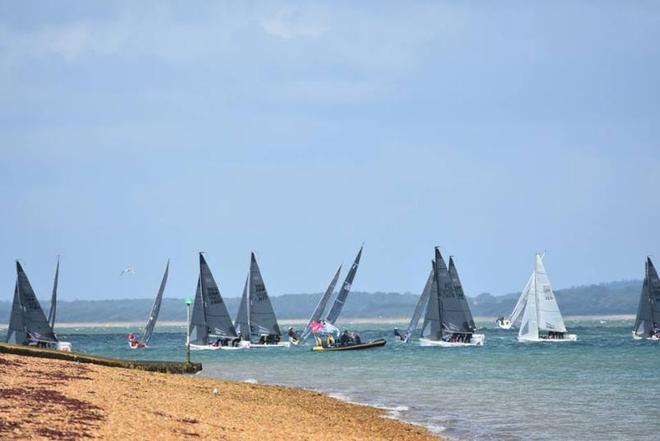 The gravel beach at Cowes with the SB0 fleet close tacking to avoid the strong tide – SB20 Cowes Grand Slam © Jane Austin